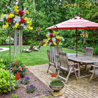 Patio Display with Multiple Arrangements
Floral wind chimes displayed in a backyard garden and patio area, showing versatility for memorial or outdoor décor.