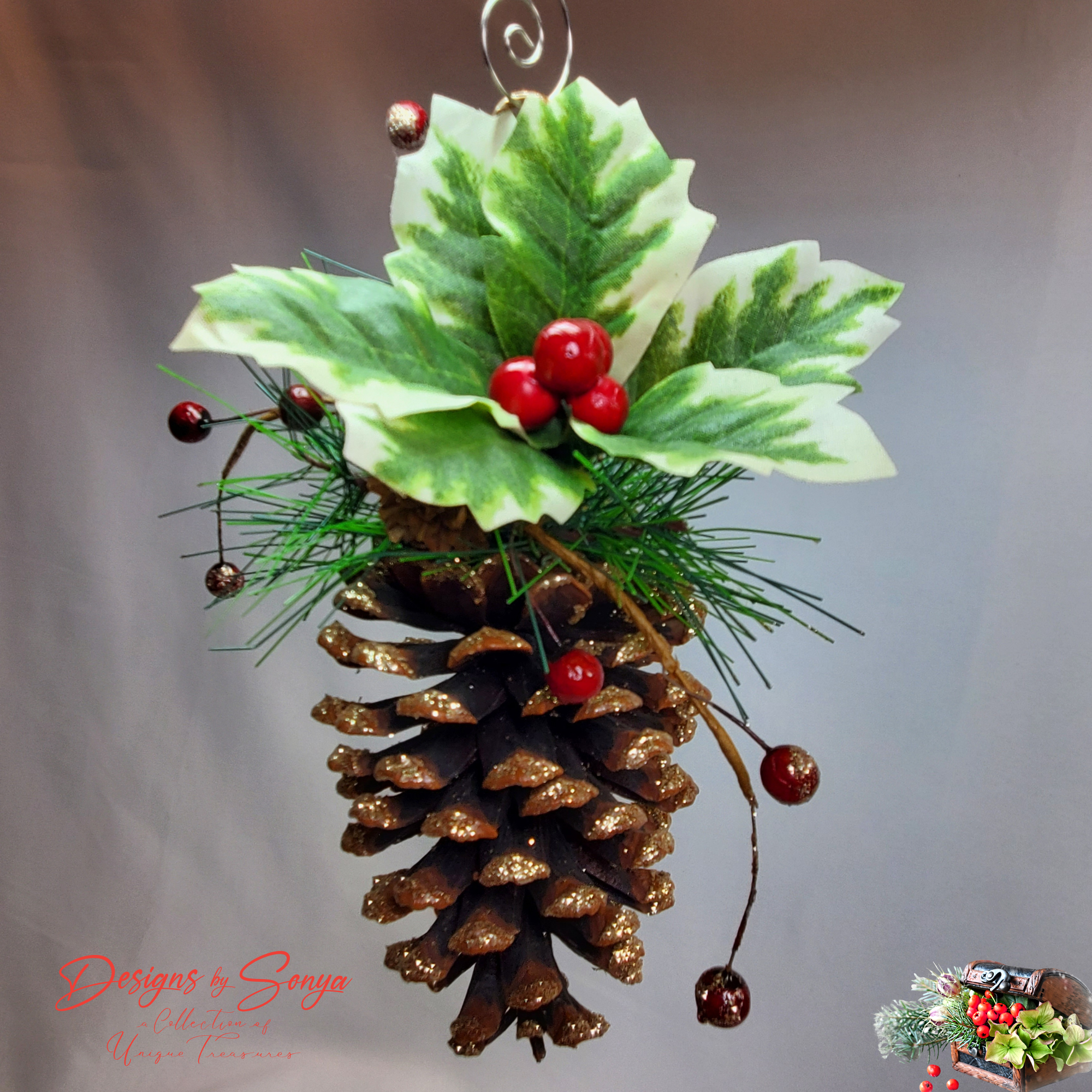 Rustic Pinecone Ornament on Neutral Background
Close-up of a handcrafted pinecone ornament featuring holly leaves, pine needles, red berries, and gold glitter detail.