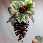 Warm-Tone Hanging Close View
Rustic handmade pinecone ornament shown hanging, highlighting layered holly leaves, red berry cluster, burlap ribbon loops and polished gold bell; cozy holiday accent.